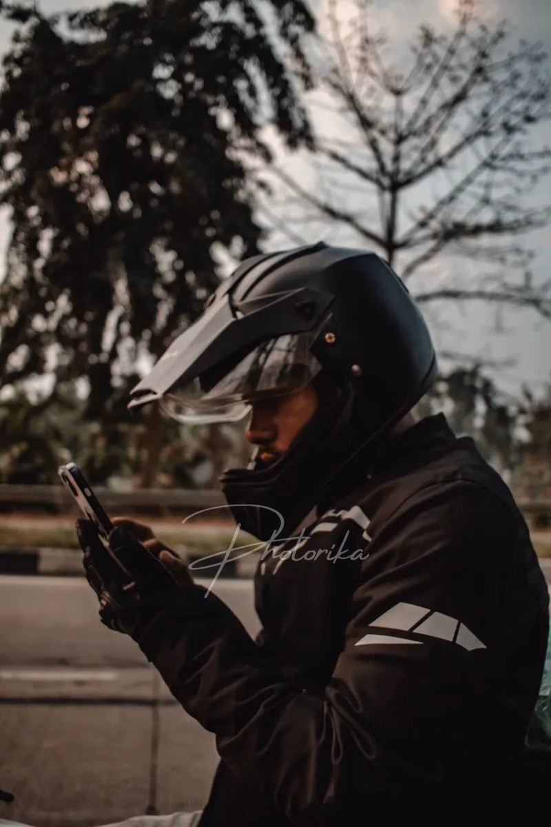 rider-in-full-gear-looking-at-mobile-phone