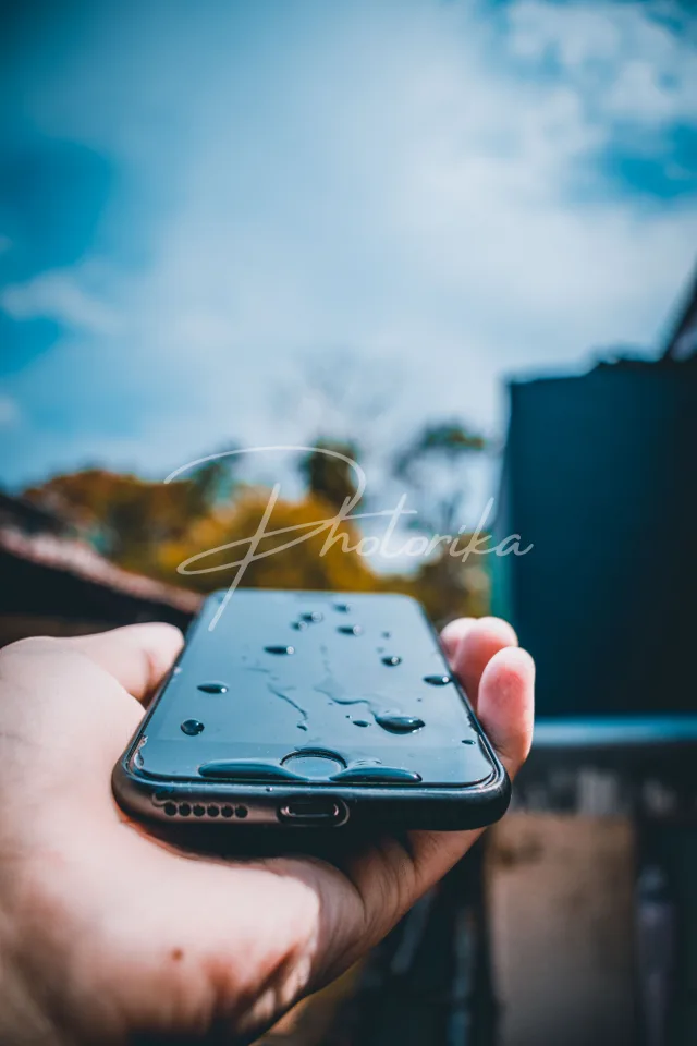 hand-holding-phone-water-drops
