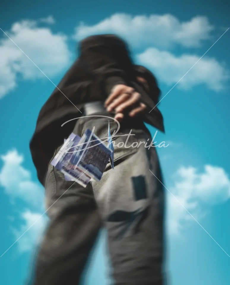 man-throwing-cash-blue-sky