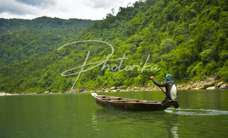 man-boating-green-hills-green-water