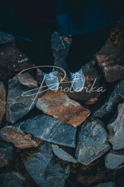 man-with-sneakers-standing-on-rocks