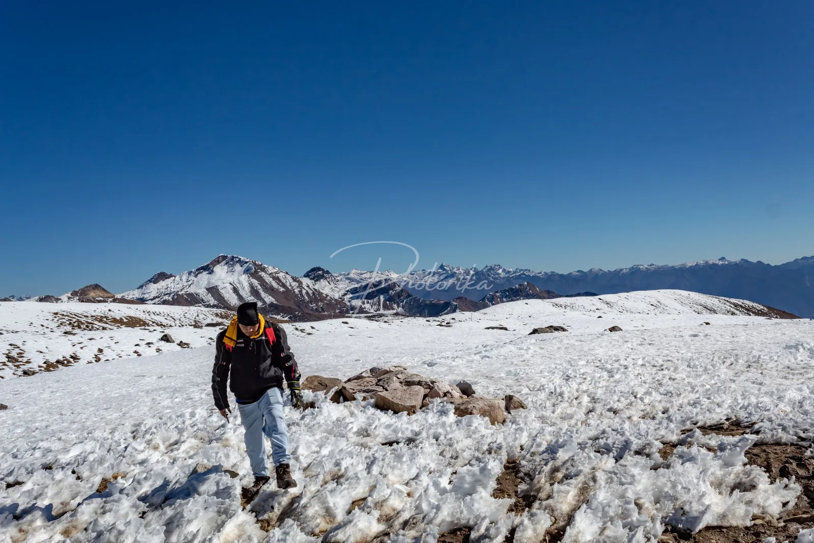 man-walking-on-snow-surrounded-by-mountains